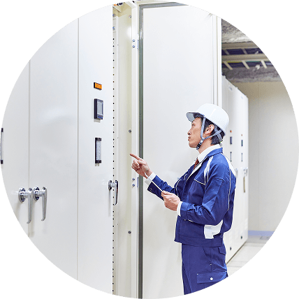 電気制御盤を点検する作業員