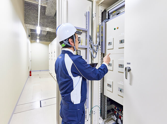 電気制御盤を点検する作業員